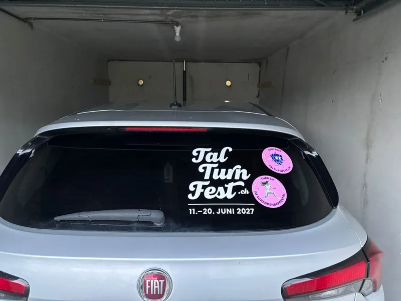 Talturnfescht-Autochläber am Heckfänschter vo emene Auto